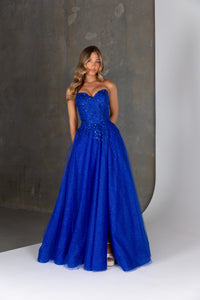 Woman wearing a blue strapless gown against a neutral background